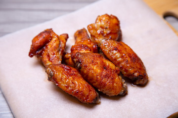 BBQ chicken wings on paper. Close-up, selective focus.