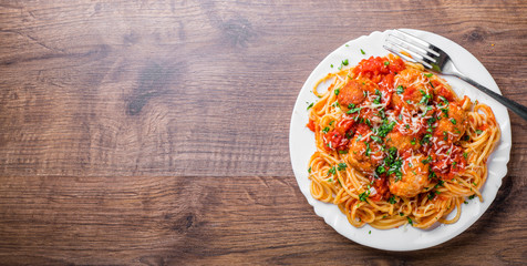 pasta spaghetti with meatballs in tomato sauce on a plate on dark wooden background