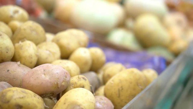 Social market concept, cheap products. woman picks potatoes in a grid on the counter in the store