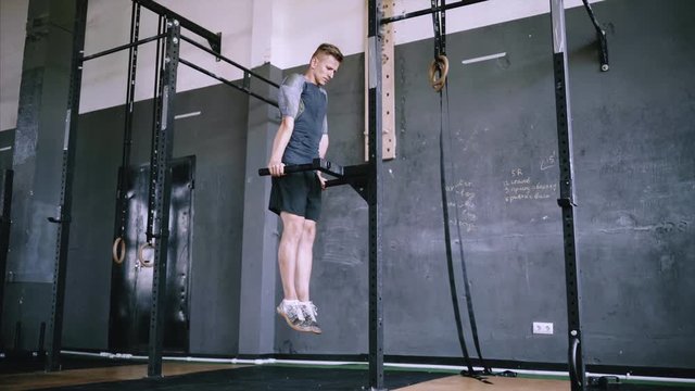 Man does triceps dip exercise in gym on parallel bars or dip stantion. Athlete dressed in comfortable sportswear. Clothes are comfortable and absorb sweat. Muscular man doing bodyweight dips, strength
