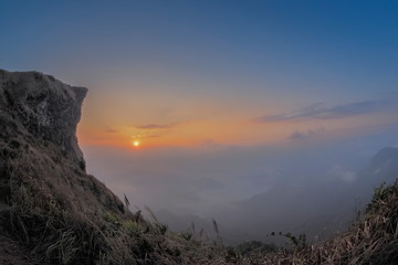 Mountain view of Phu Chi Fa Mountain around with sea of fog with red sun light in the sky background, sunrise at Phu Chi Fa (Phu Chee Fah), Chiang Rai, Thailand.