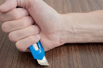knife in hand on brown background.