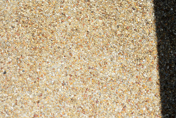 Pebble stone floor texture close up with shadow on it. Abstract background