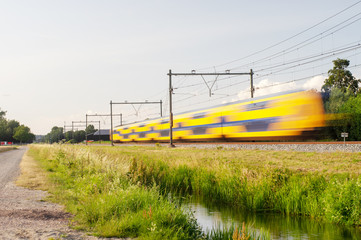 Dutch railway train with speed, with long exposure.