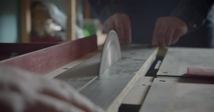 Close-up shot headsaw cutting the wood boards at manufacture .