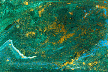Liquid uneven green marbling pattern with golden glitter and glare of light
