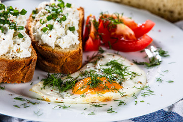 Breakfast - fried egg, toasts and vegetable salad