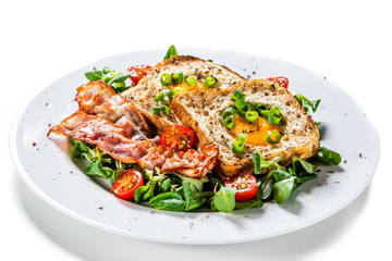 Breakfast - toasted bread with fried egg, bacon and vegetables