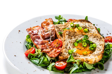 Breakfast - toasted bread with fried egg, bacon and vegetables