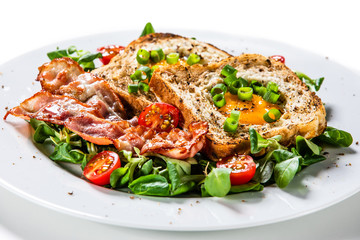 Breakfast - toasted bread with fried egg, bacon and vegetables