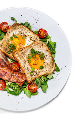 Breakfast - toasted bread with fried egg, bacon and vegetables