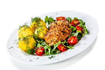 Grilled chicken fillet and vegetables on white plate