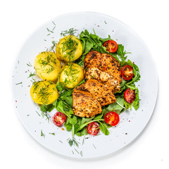 Grilled chicken fillet and vegetables on white plate