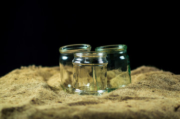 glass jars on a black background for storing food for the winter