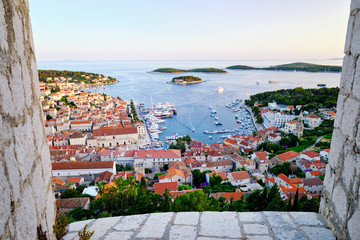 Beautiful view over the walls of the evening harbor in Hvar, Croatia - obrazy, fototapety, plakaty