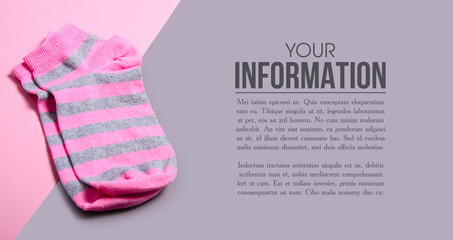 Pink socks on pink gray background, space for text