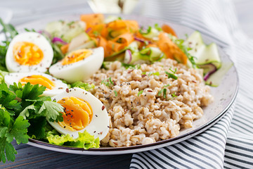 Breakfast bowl with oatmeal, zucchini, lettuce, carrot and boiled egg. Fresh salad. Healthy food. Vegetarian buddha bowl.