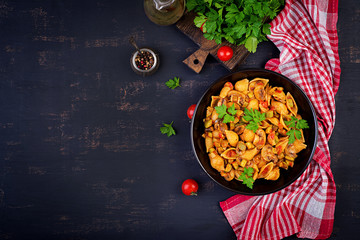Conchiglie pasta. Italian pasta shells with mushrooms, zucchini and tomato sauce.  Top view