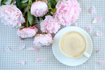 morning oatmeal cappuccino on a gray napkin in peonies