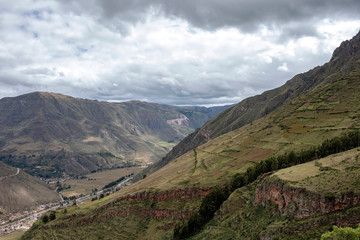 Landscape with green Andean Mountains and Inca ruins on the hiking path in Pisac archeological park, Peru