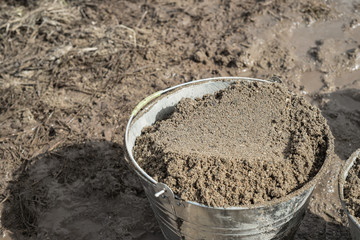 close up gravel stone in cement buckets prepared for building work in construction building. building construction site. industry. Bucket of sand on the construction site. close up.