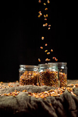 corn grain falls on glass jars