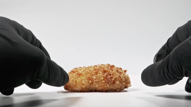 man breaking fresh Homemade traditional Spanish croquettes or croqueta tapa espa&ntilde;ola