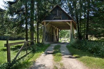 Fototapeta na wymiar Alte überdachte Holzbrücke - Barbara Brücke mit Wanderweg am Ende der Schlichemklamm bei Epfendorf im Schwarzwald, Deutschland