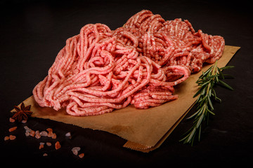 closeup raw forcemeat served with spices and rosemary