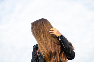 Young girl with long hair. Pretty haircut. Fashion have youth. It's time for a party. Teen carelessness. Girls hide face. How to call for a date.