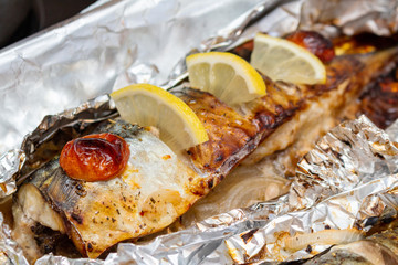 Fried mackerel on the foil with lemon and cherry tomatoes healthy delicious tasty food close up selective focus
