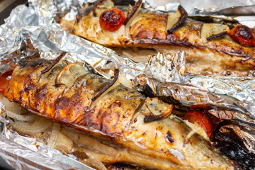 Fried mackerel on the foil with lemon and cherry tomatoes healthy delicious tasty food close up selective focus