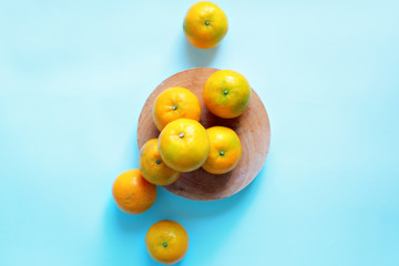 Tangerines in bowl on blue background. Super food