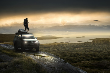 Mann steht auf Geländewaagen an der Küste