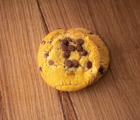 Homemade biscuits with chocolate pieces on a light wood table. View from above