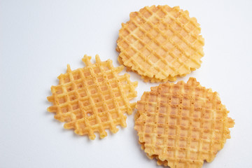 Three crispy belgian waffles on white tablecloth