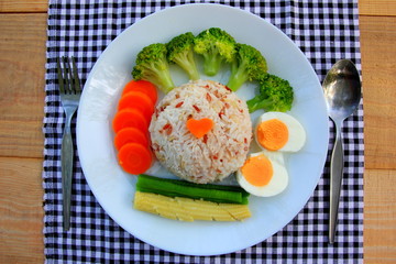 Clean food have brown rice, broccoli,carrot,Lentils,Baby corn,and egg in white disc on the wood table, healthy or vegetarian food concept Top view. 
