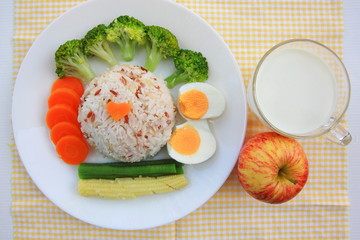 Clean food have brown rice,milk,apple broccoli,carrot,Lentils,Baby corn,and egg in white disc on the wood table, healthy or vegetarian food concept Top view. 
