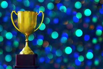 Winner hold trophy with abstract bokeh light background