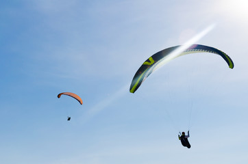 Paragliding in the sky. Two paraglider fly over the mountain valley. Competitions with paragliding, Russia, Siberia