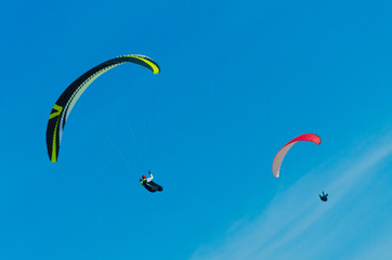 Paragliding in the sky. Two paraglider fly over the mountain valley. Competitions with paragliding, Russia, Siberia