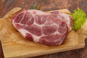 Raw pork steak over wooden board