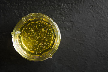 Sweet healthy organic light flower honey in the jar over black background with copy space