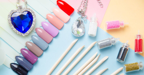 manicure set and a diamond on pastel background top view. Manicure fashion modern bright background. Trendy minimal pop art style and pastel colors