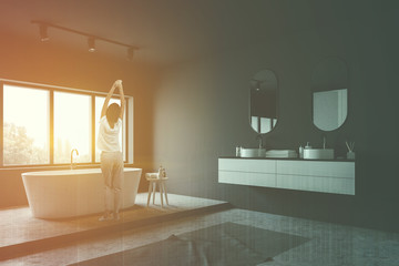 Woman in gray bathroom corner