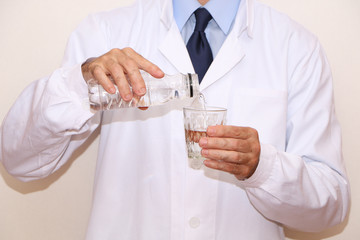 Healthy Eating - Doctor pours mineral water into a glass