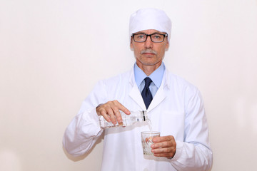 Healthy Eating - Doctor pours mineral water into a glass