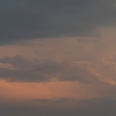 Orange sunlight in a cloudy sky showing a weather condition before it starts to rain. 