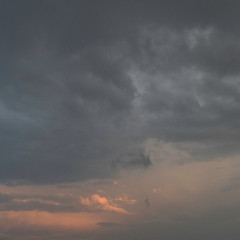 Orange and dark grey clouds in the sky, before the rainfall comes.