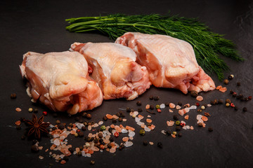 closeup top view of three parts of raw chicken with green dill